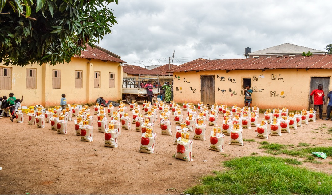 Rows of food parcels laid out in a compound courtyard, prepared for one hundred vulnerable households.