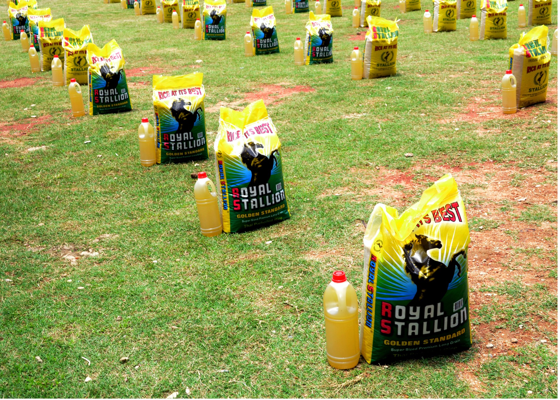 Food parcels of rice and vegetable oil arranged on grass, ready for distribution to vulnerable households in Nigeria.